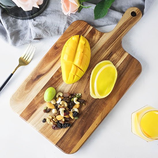 mangue coupée et noix sur planche à découper bois