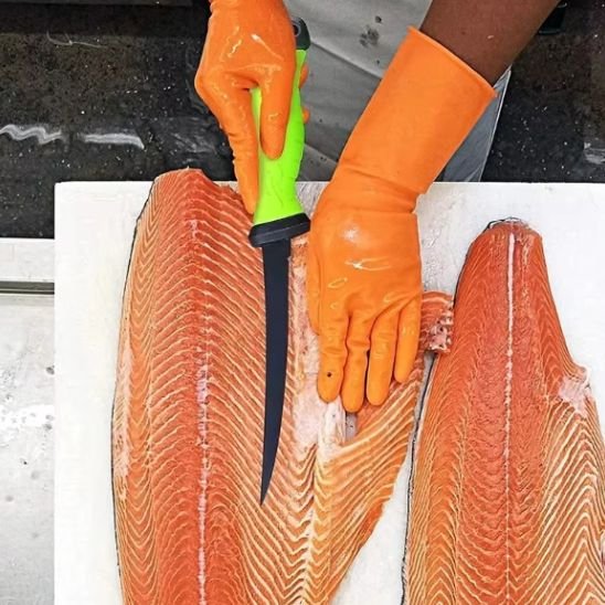 personne coupe saumon avec couteau de cuisine avec gants orange