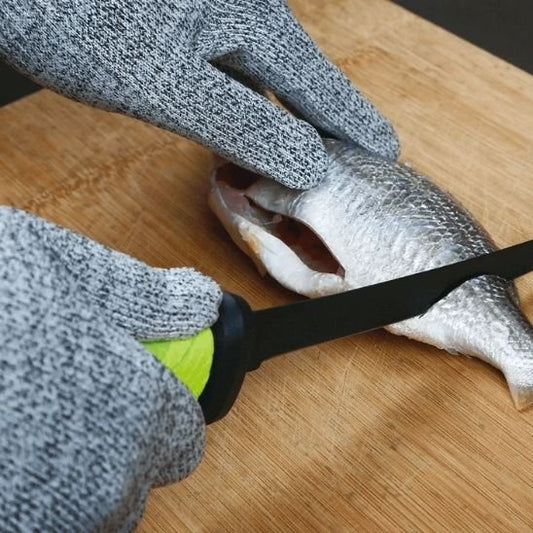 personne coupe un poisson avec couteau de cuisine avec gant anti coupure